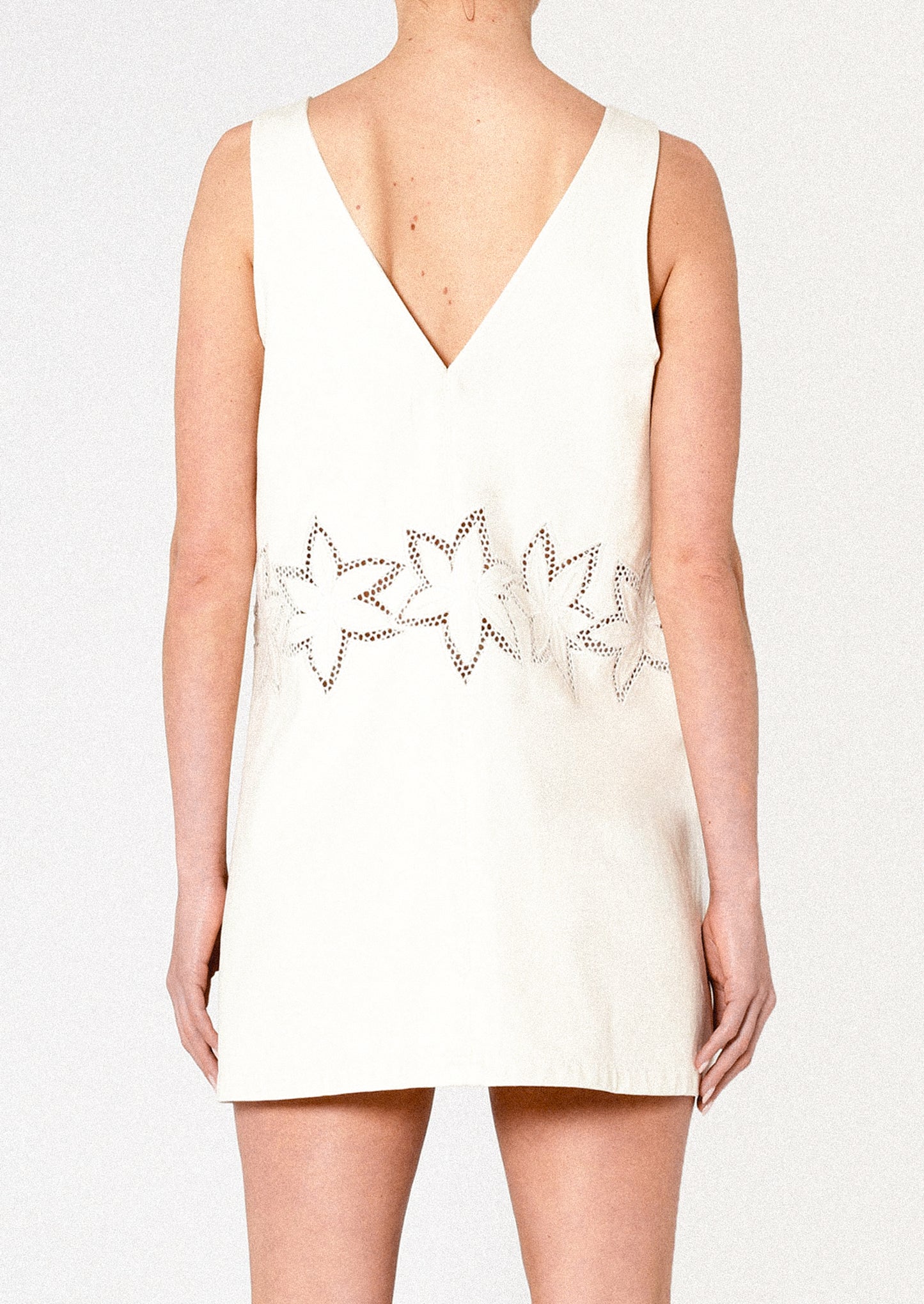 White dress with star-shaped embellishments on a plain background