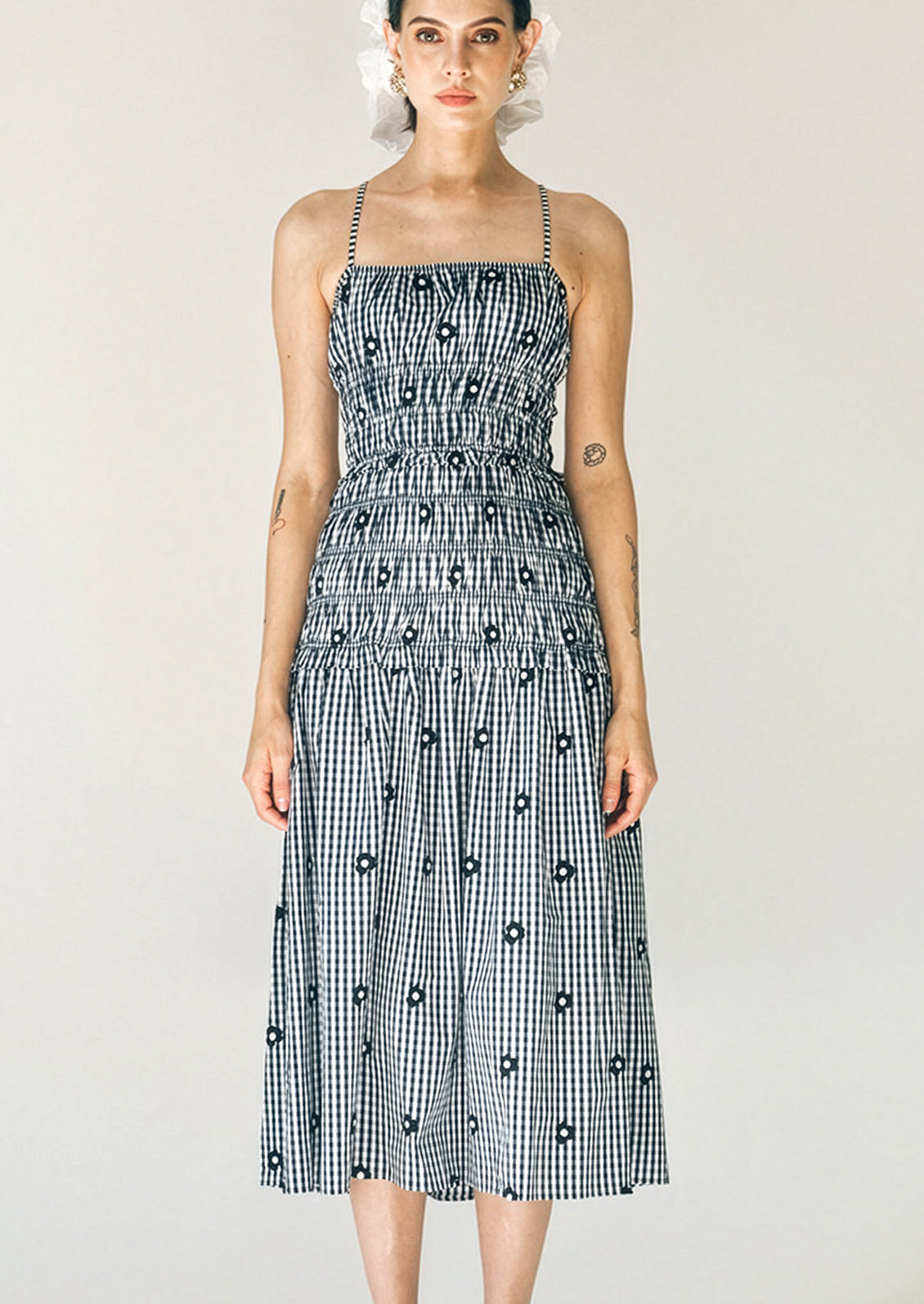 Woman wearing a black and white checkered dress with a plain background