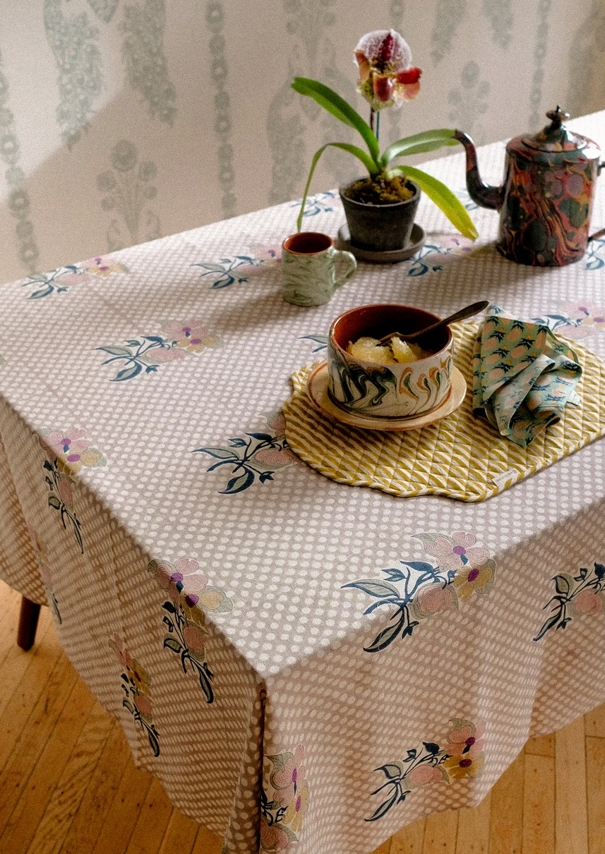 A polka dot tablecloth with floral motif.