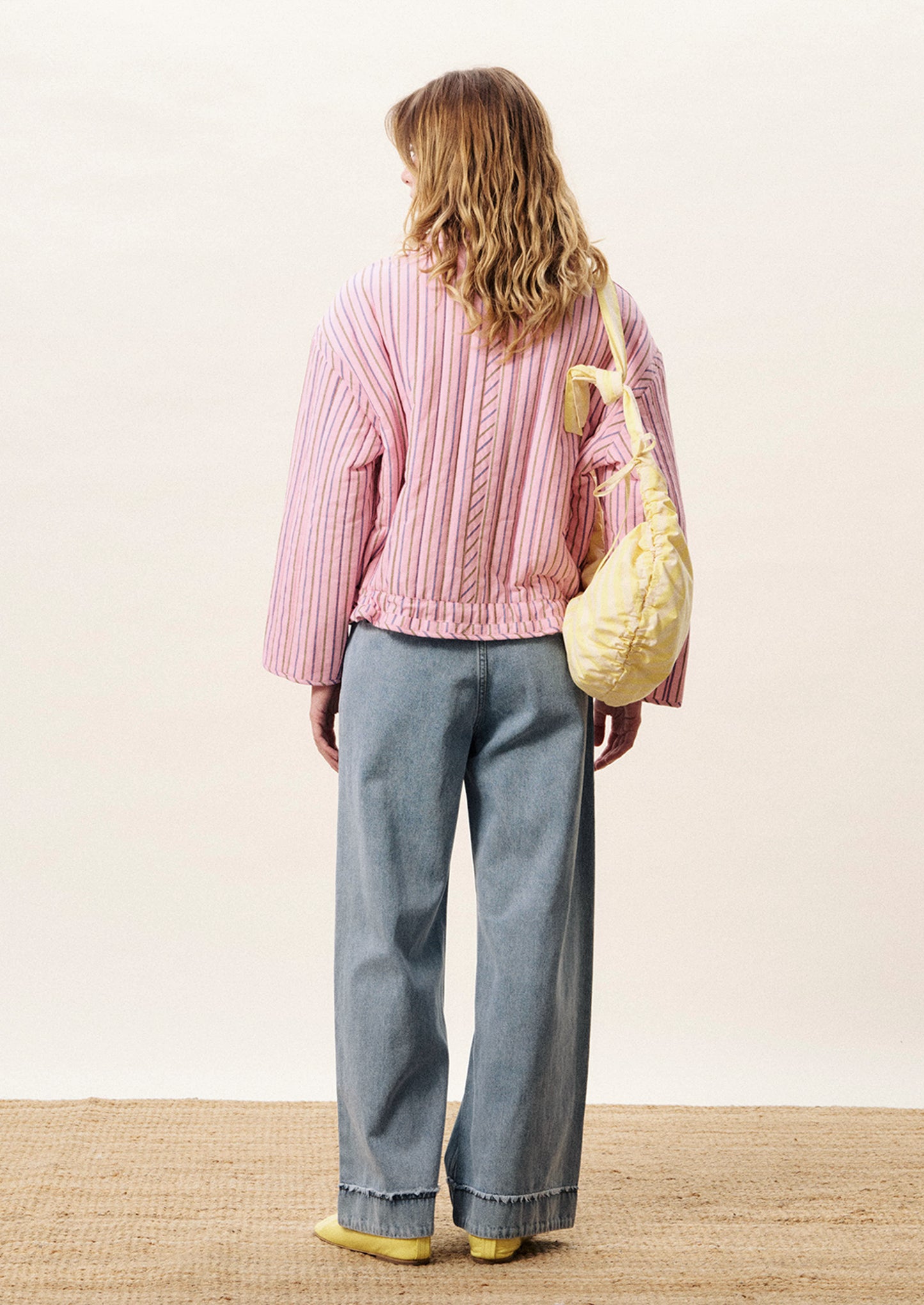 Person wearing a pink striped jacket with a white background