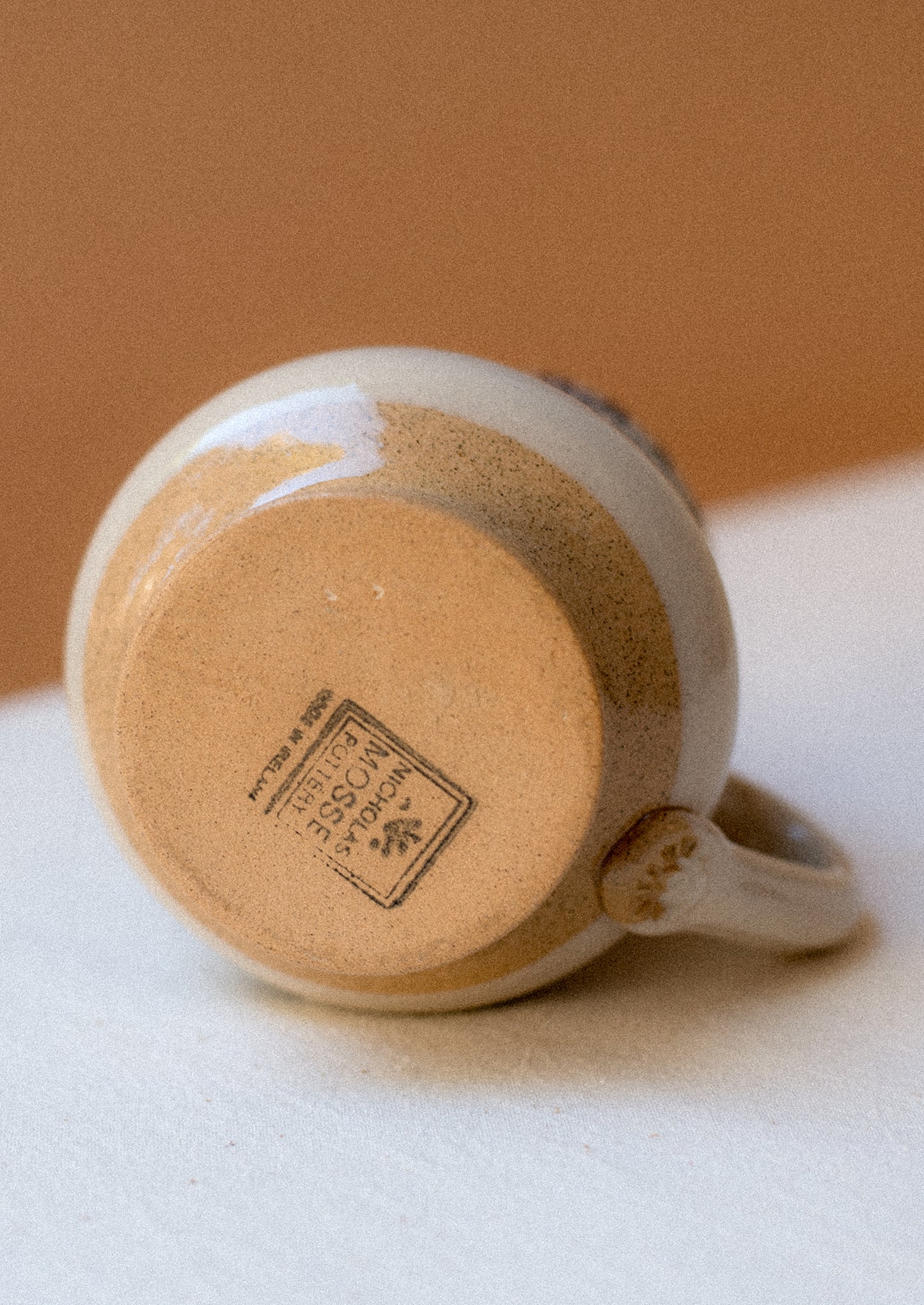 A ceramic pitcher with hand painted pansy floral pattern.