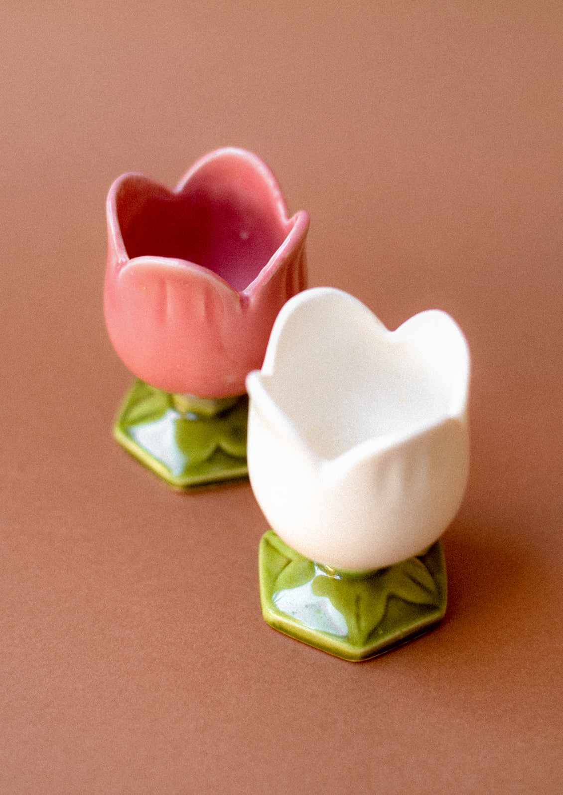 A pair of tulip egg cups in pink and white.