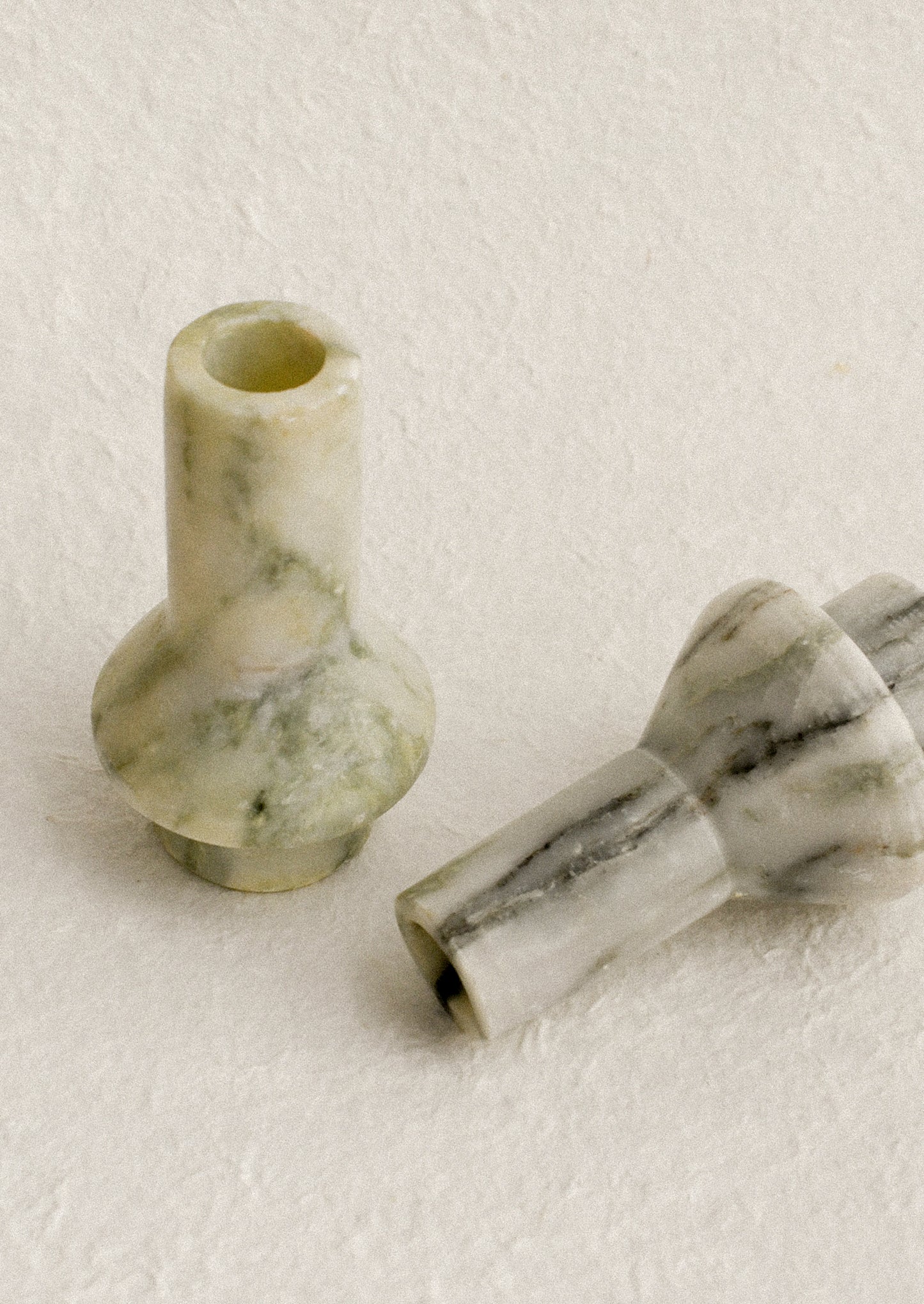 A sculptural candle holder in variegated green marble.