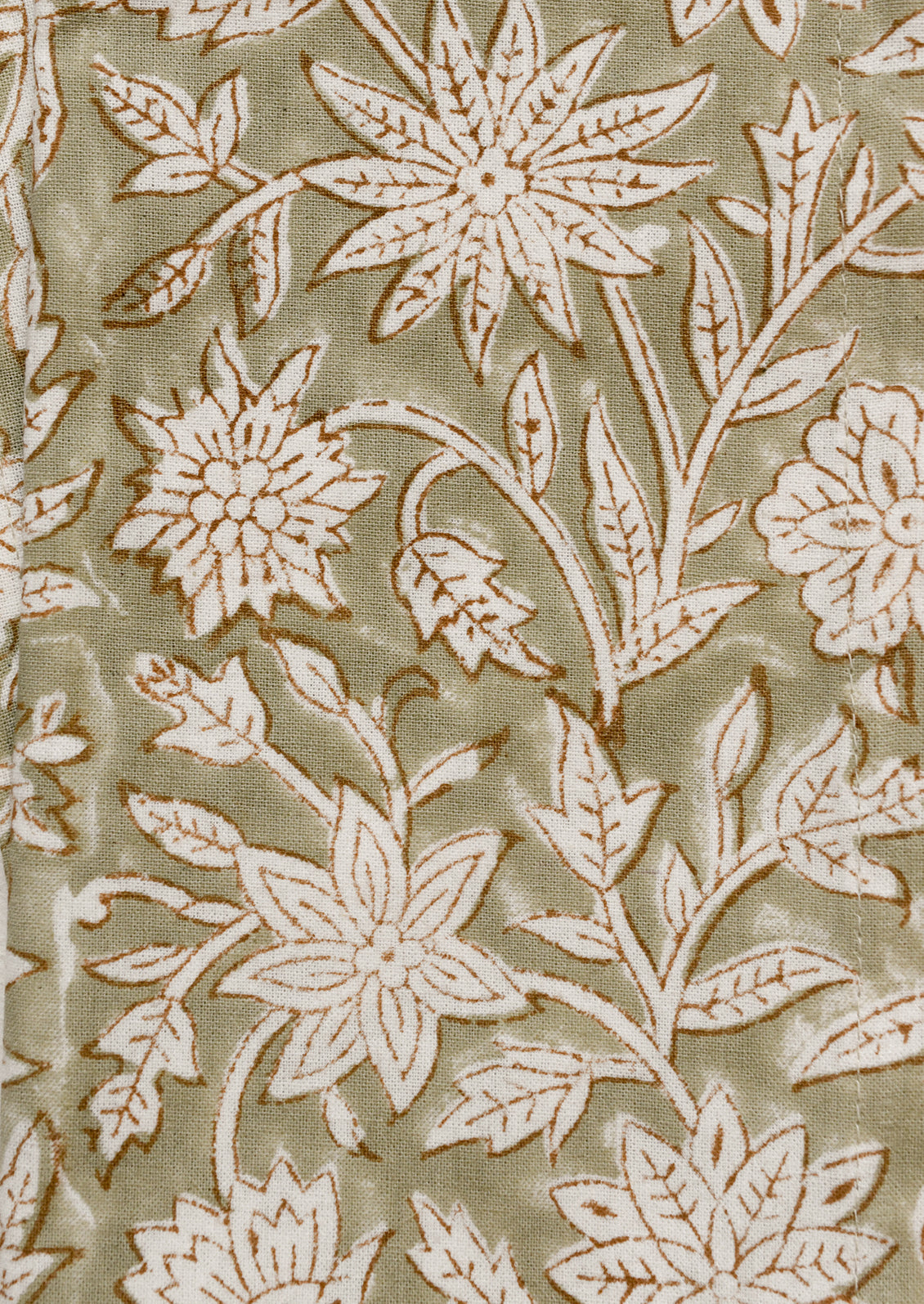 A pair of napkins in muted green color with white and brown block printed floral pattern.