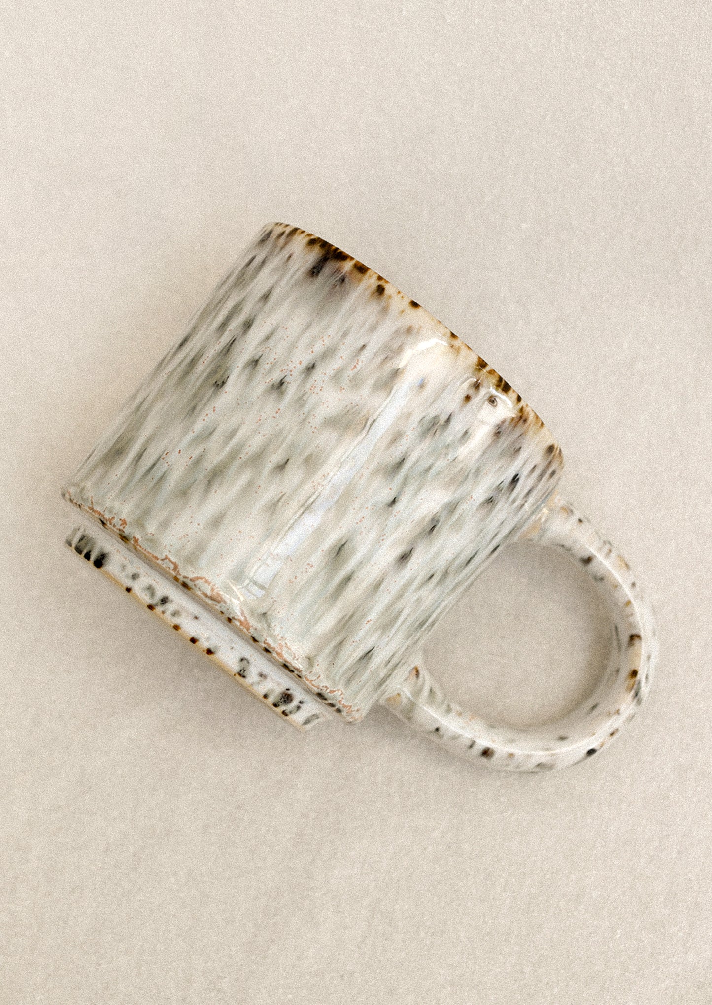 Ceramic mug with textured surface on a beige background