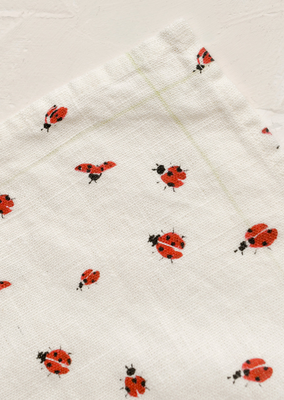 White towel with red ladybug pattern on a white background