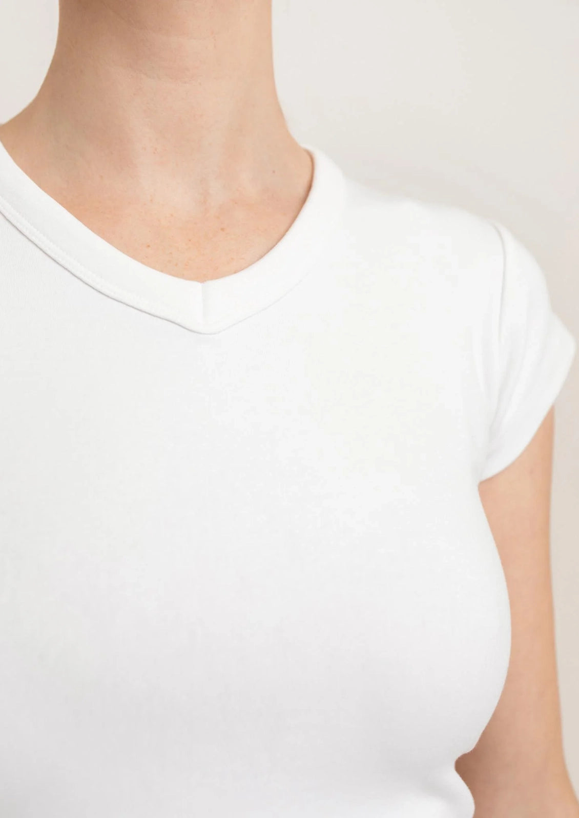 White t-shirt worn by a person on a plain background