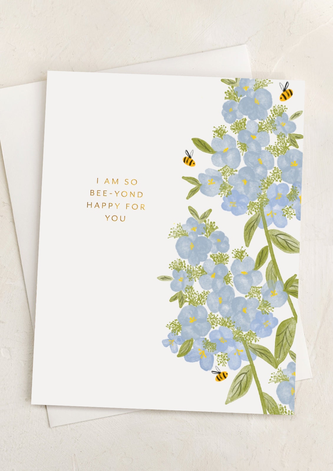 A bee and flower print card reading "I am so bee-yond happy for you".