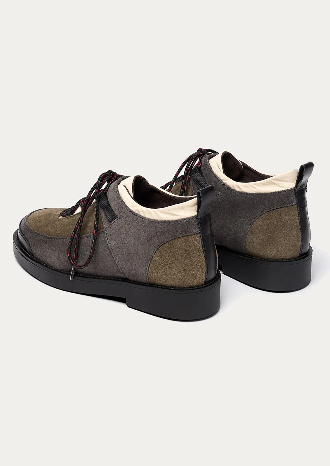 Pair of brown suede shoes with black soles on a white background