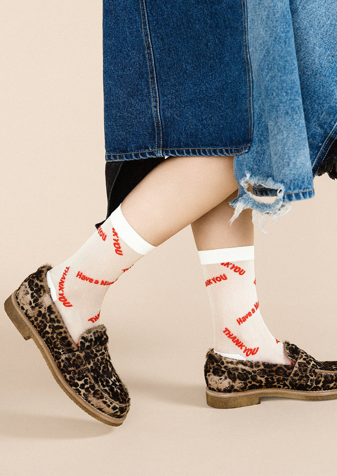 A pair of semi-sheer white socks with red lettering throughout "Have a nice day Thank You".