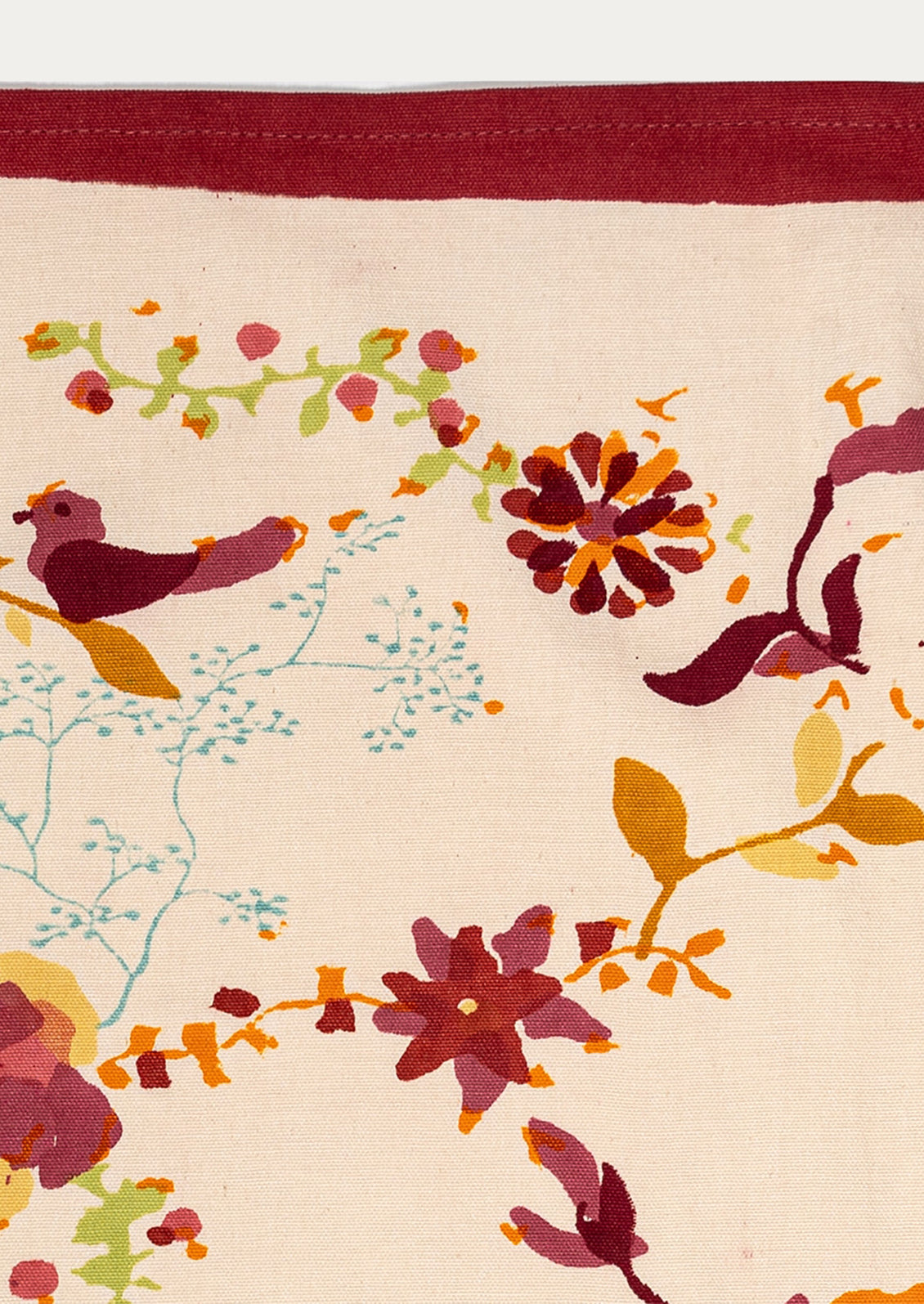 Decorative tea towel with floral and bird pattern on a beige background