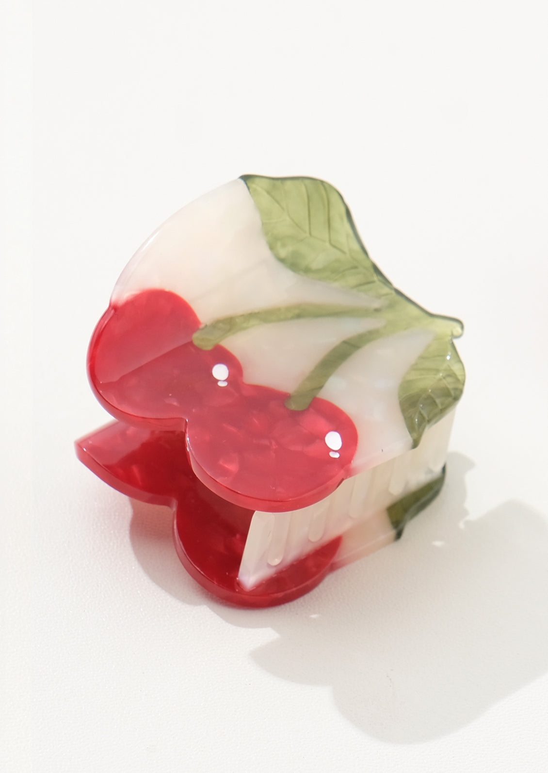 Decorative hair claw with cherry design on a white background