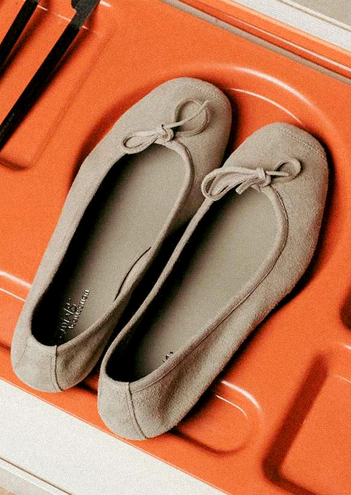 A pair of suede ballet flats in greige.