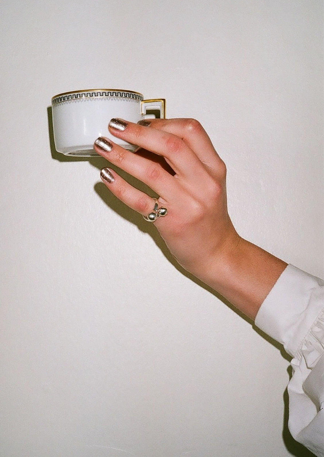 A person modeling a silver ring with sphere shapes.