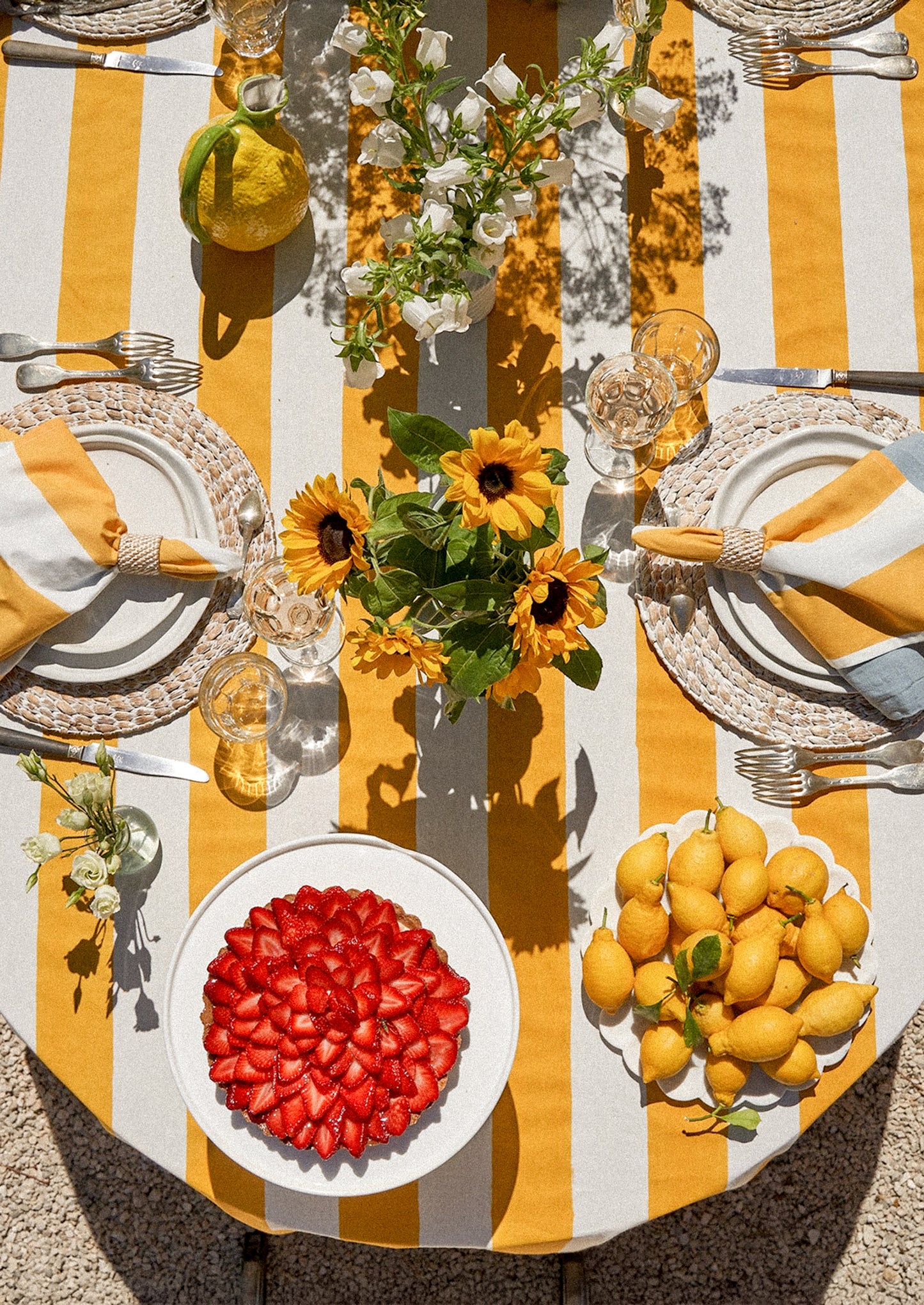 A tablecloth with wide yellow and white stripe pattern.