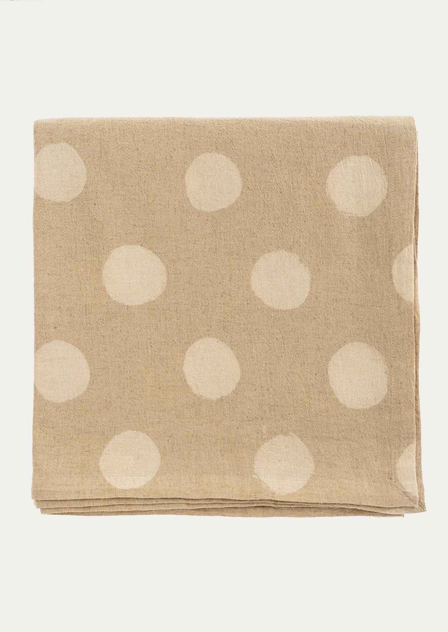 A beige tablecloth with polka dot resist pattern throughout.