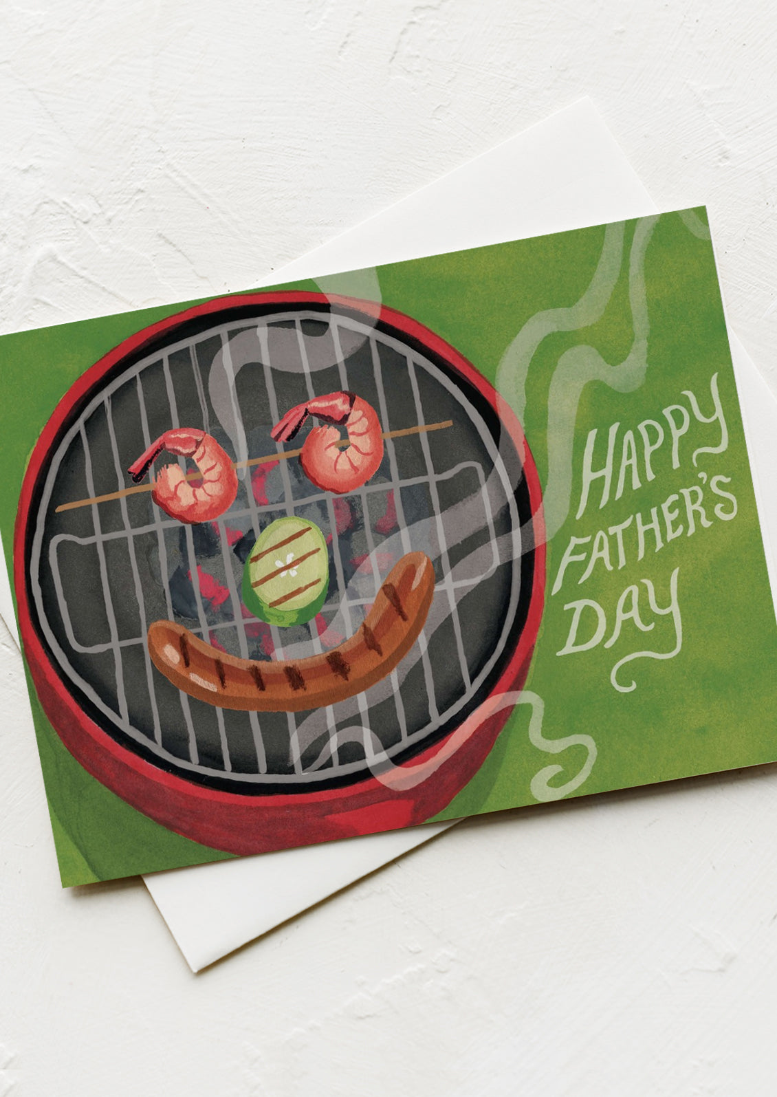 A card with image of things on grill forming a smiley face shape, text reads "Happy Father's Day".
