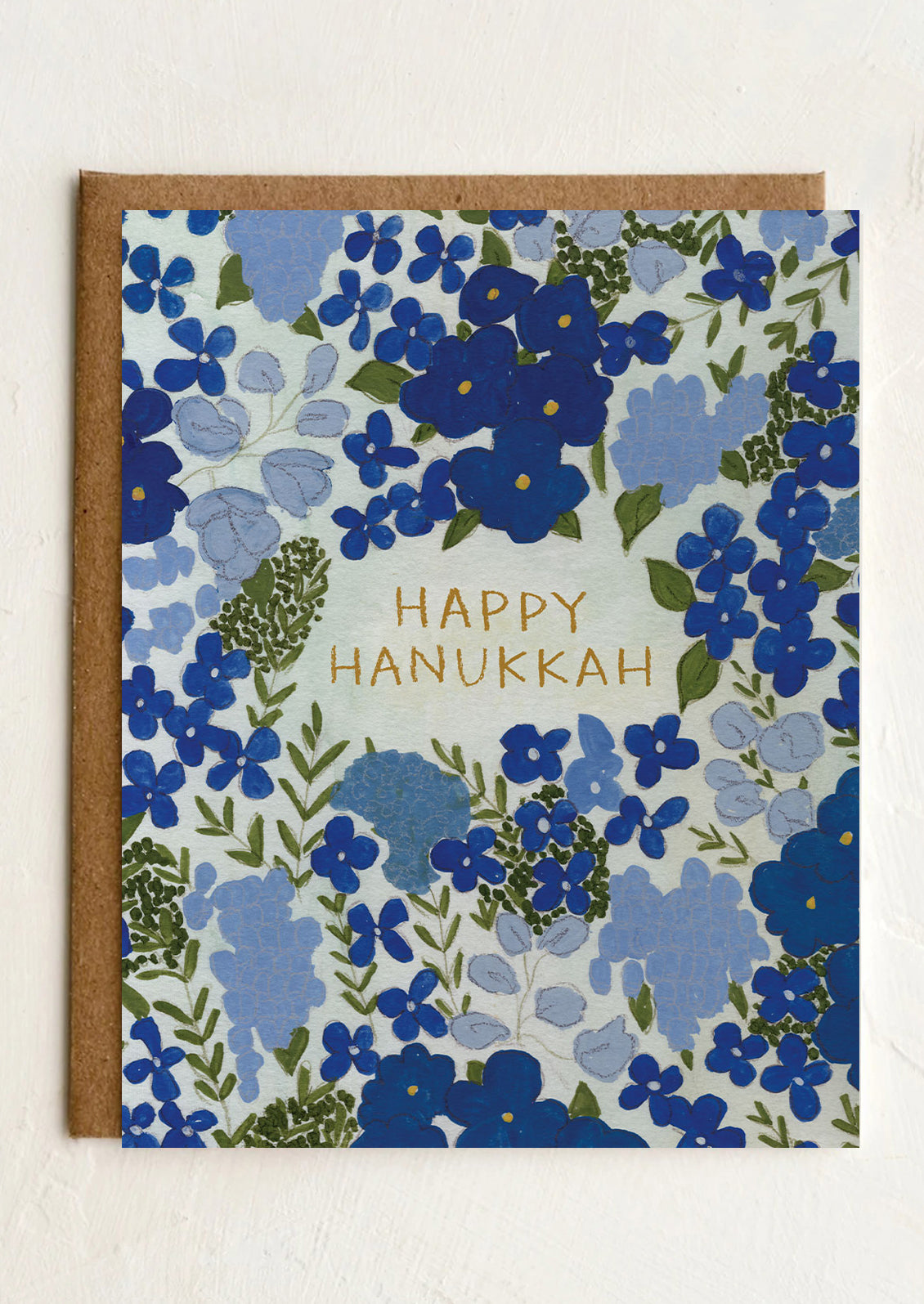 Greeting card with blue floral pattern and 'Happy Hanukkah' text on a white background