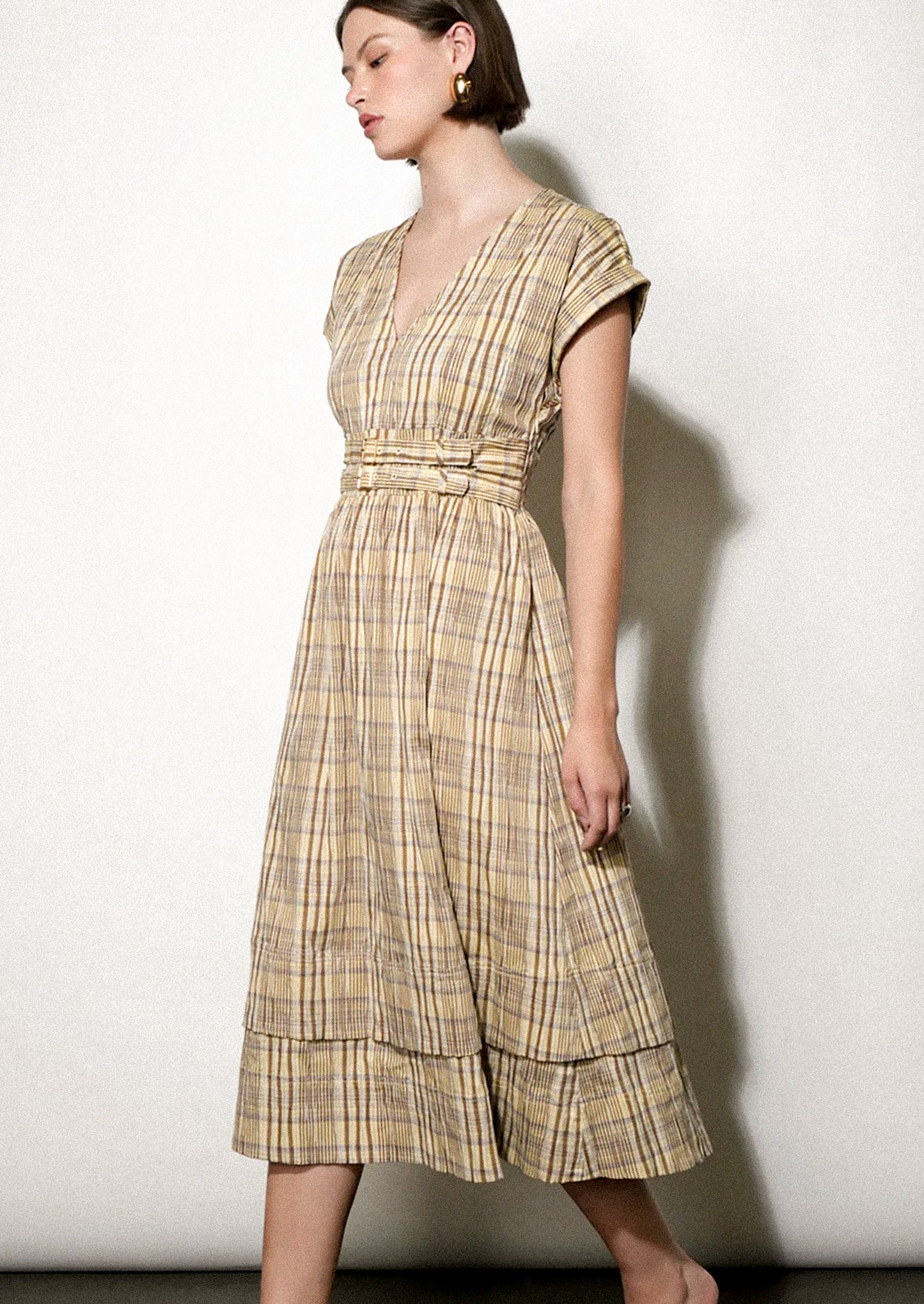 Woman wearing a plaid dress against a white background