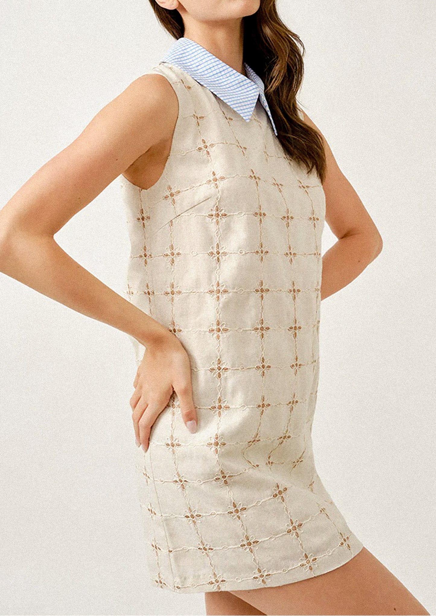 Woman wearing a sleeveless dress with a geometric pattern on a white background