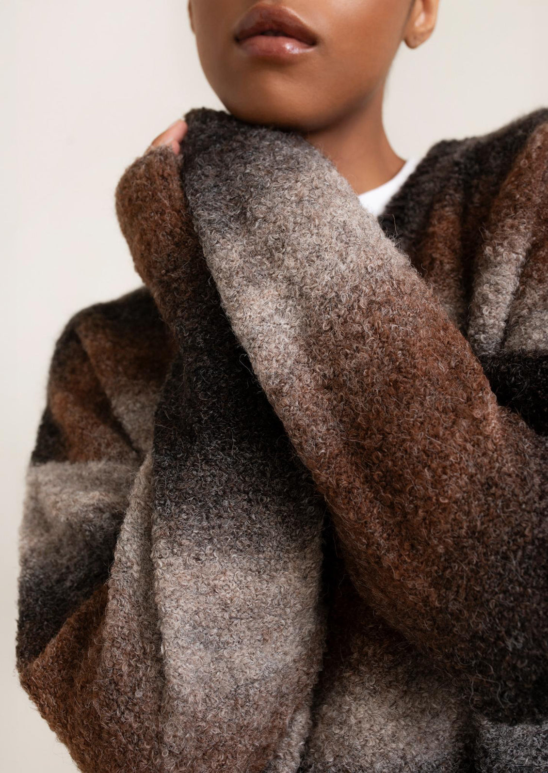 Close-up of a person wearing a patterned scarf with neutral colors.