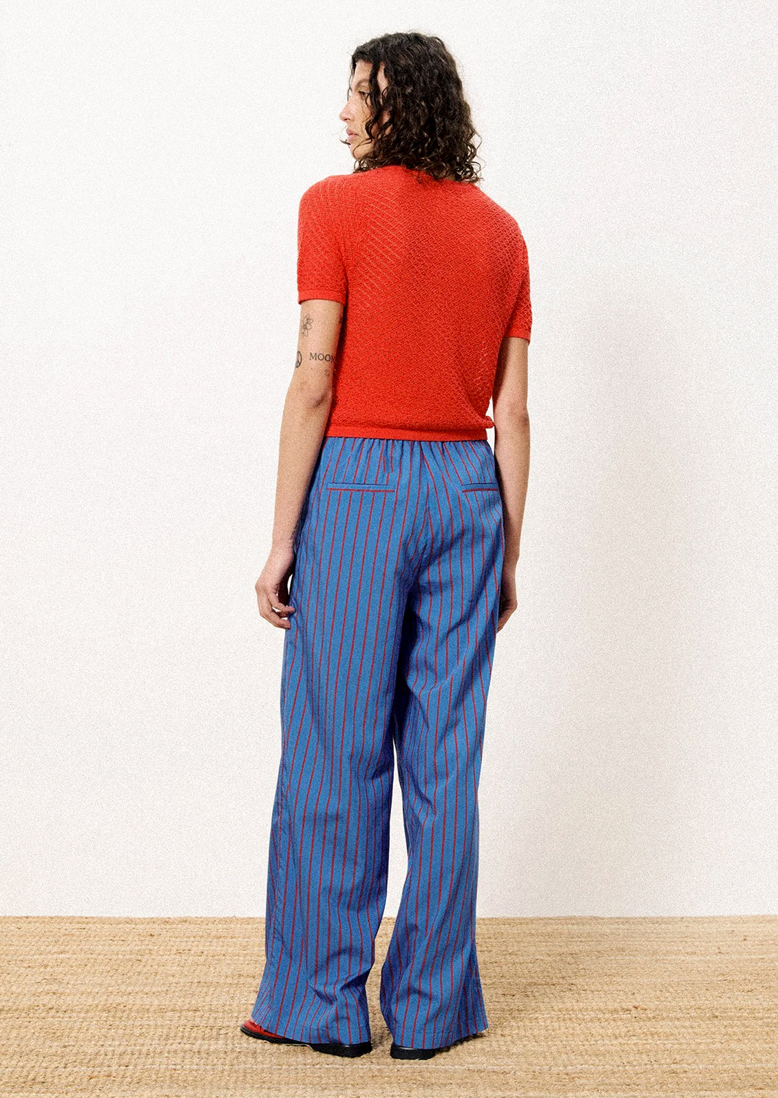 A person wearing a pair of blue and red striped long pants.