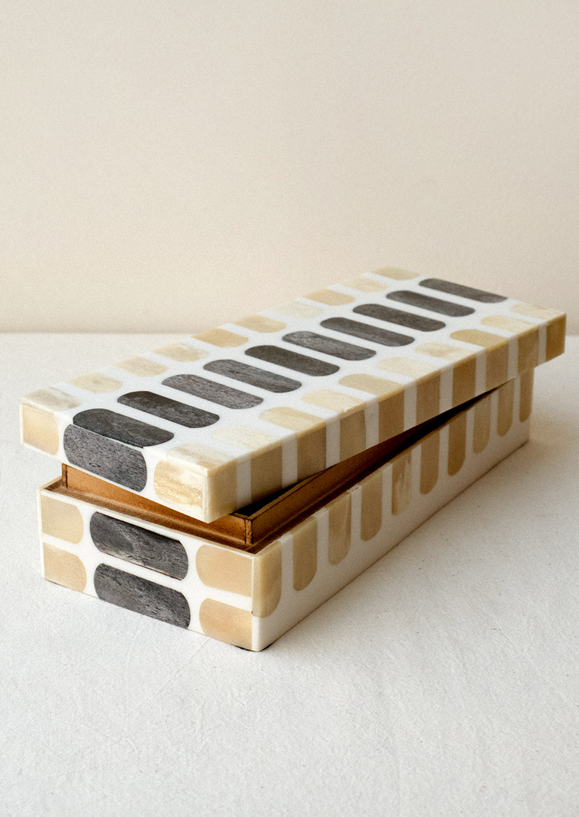 Decorative storage box made from bone with tan and grey inlay.