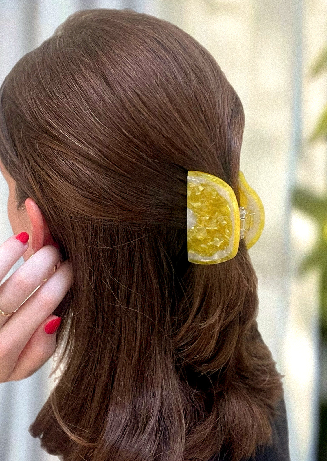 A woman wearing a hair clip in the shape of a lemon wedge.