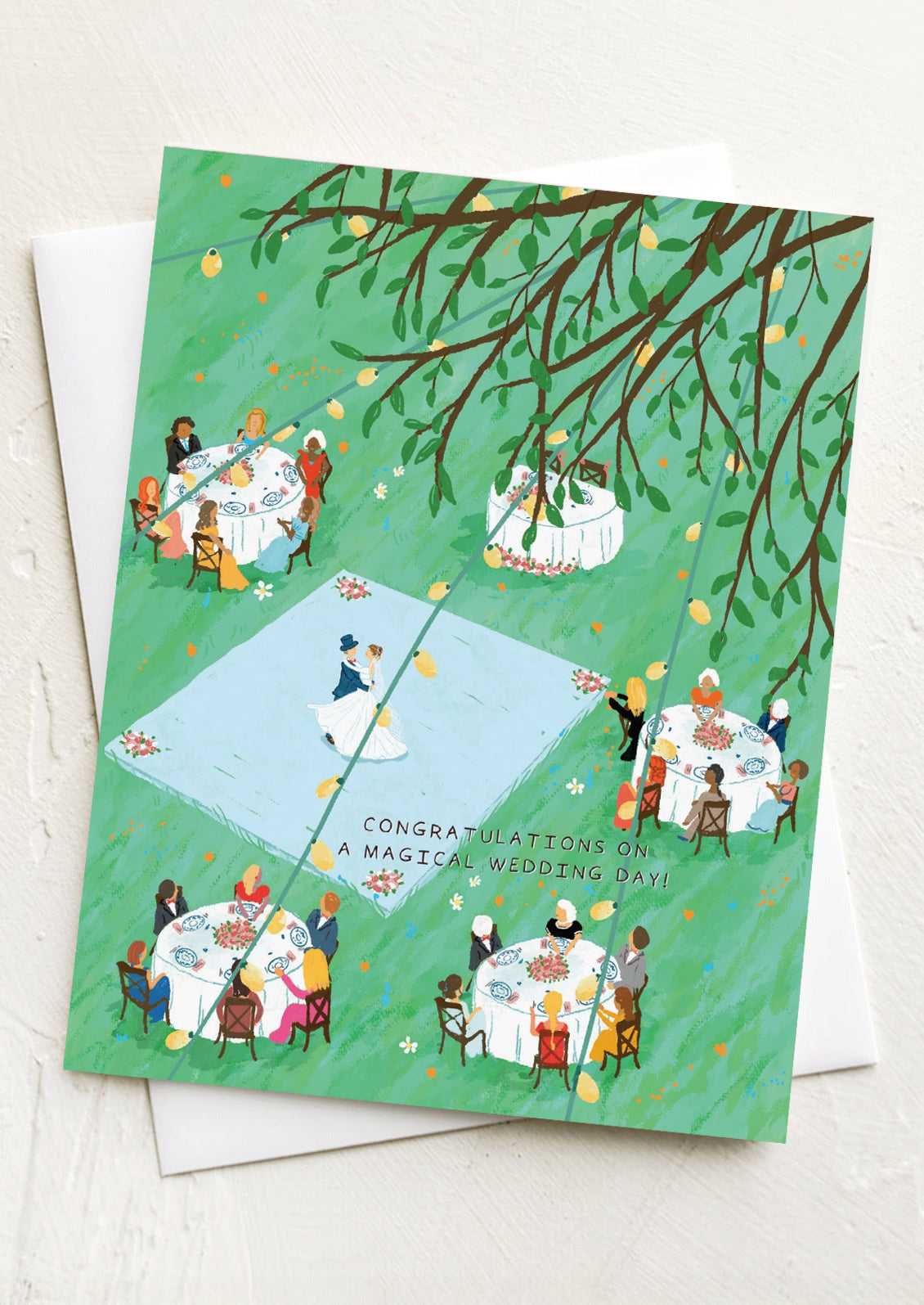 A greeting card with illustration of guests at an outdoor wedding, text reads "Congratulations on a Magical Wedding Day!".