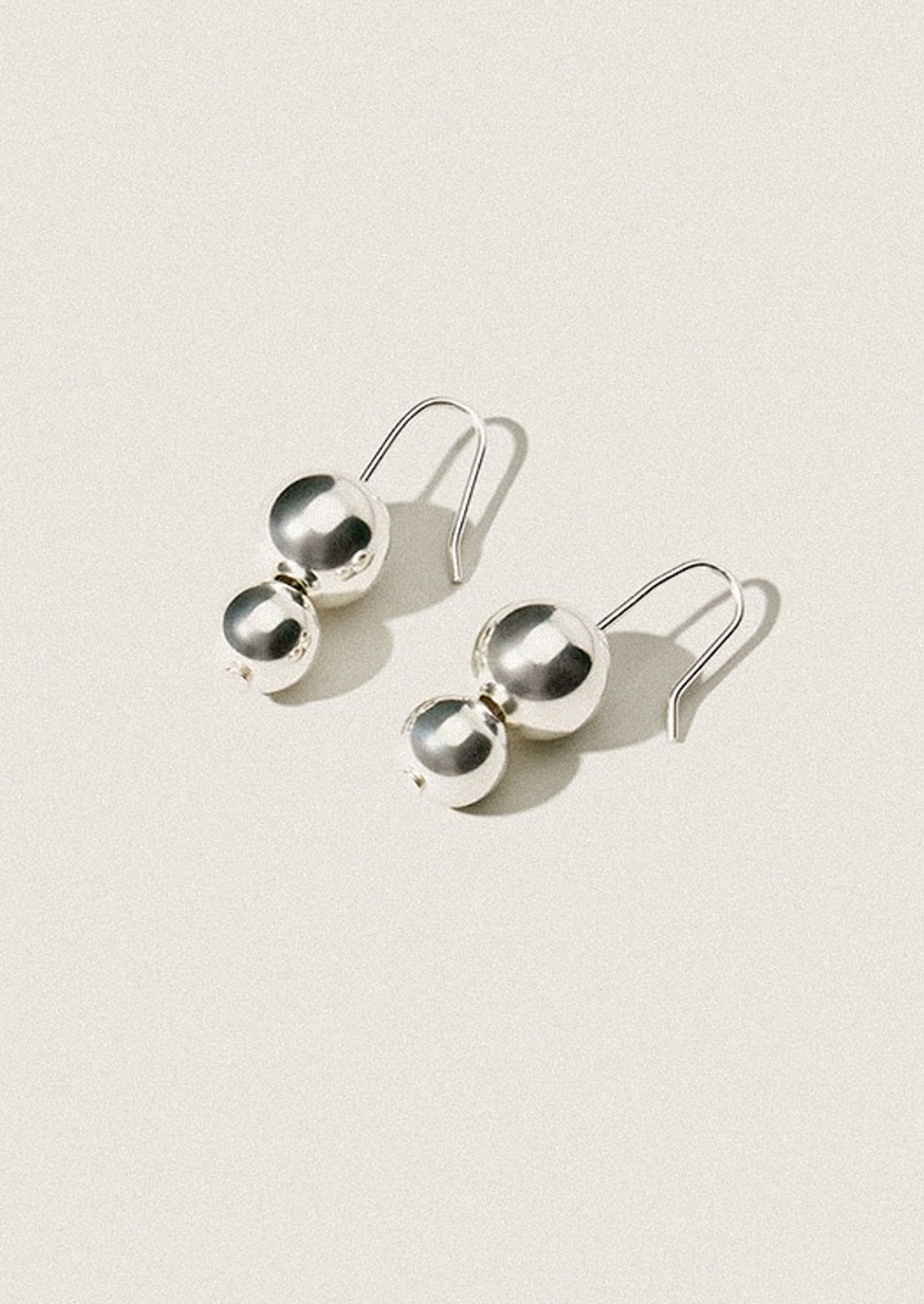 A pair of silver earrings in the shape of stacked orb.