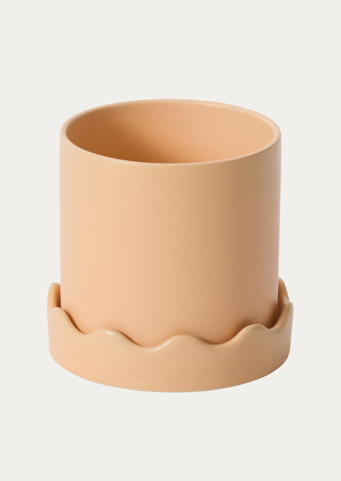 Beige ceramic planter with wavy base on a white background