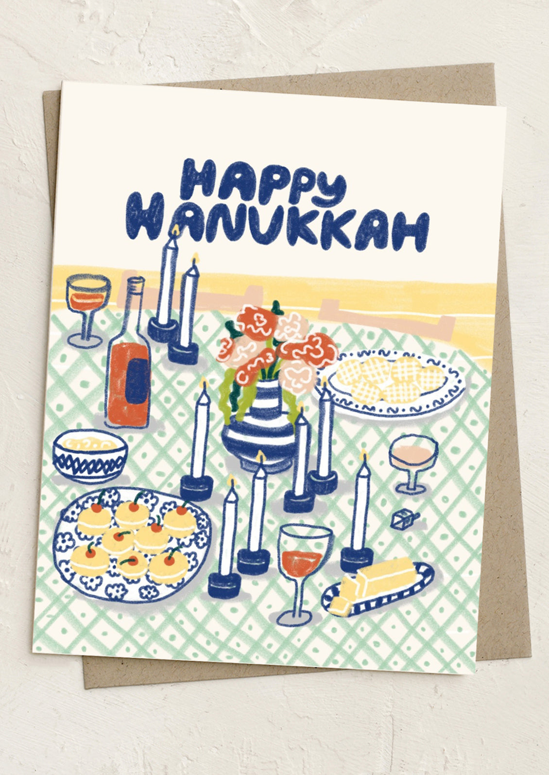 Hanukkah card with candles, wine, and food on a checkered background