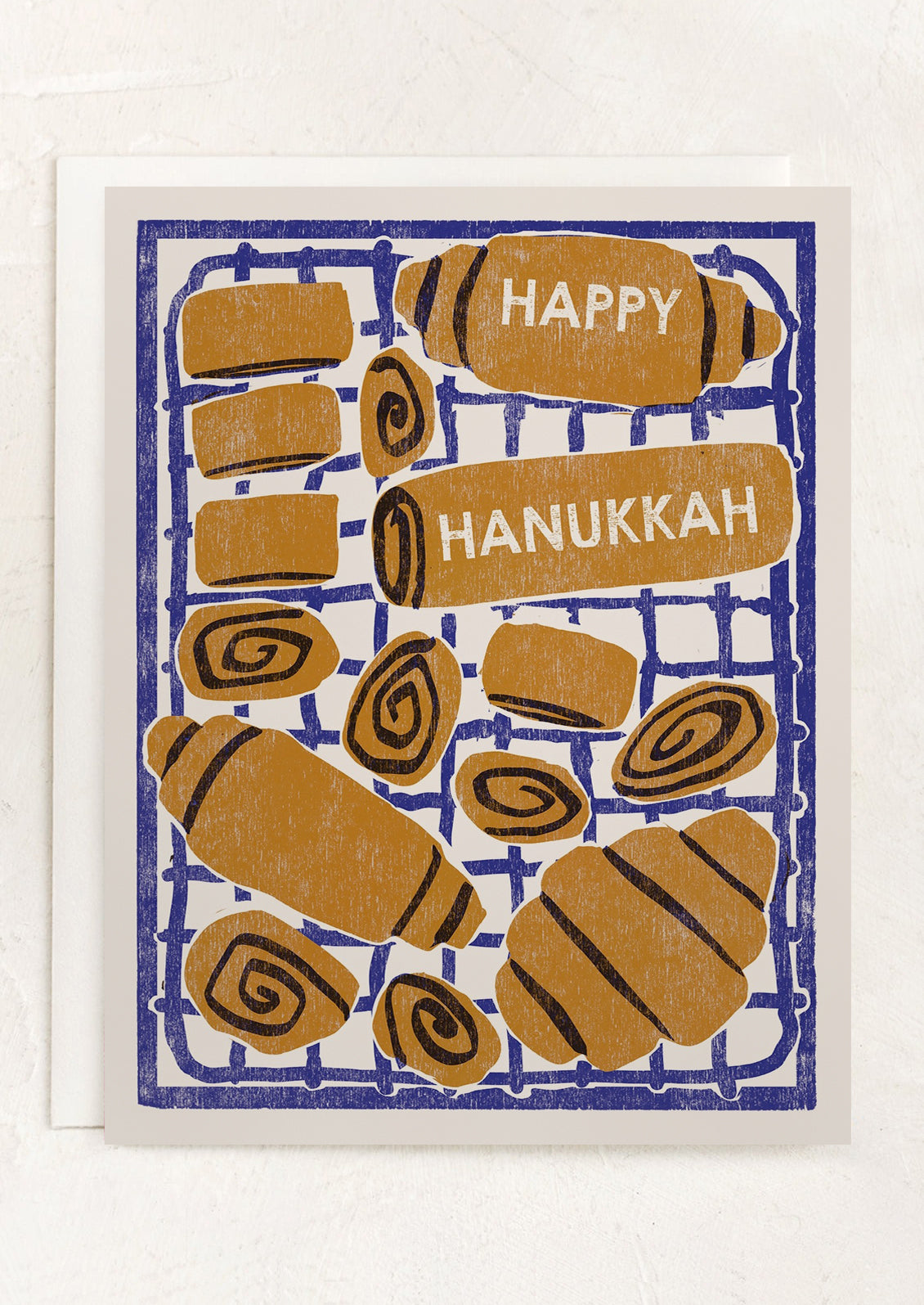 Card with Hanukkah-themed design featuring rugelach and 'Happy Hanukkah' text on a blue grid background.