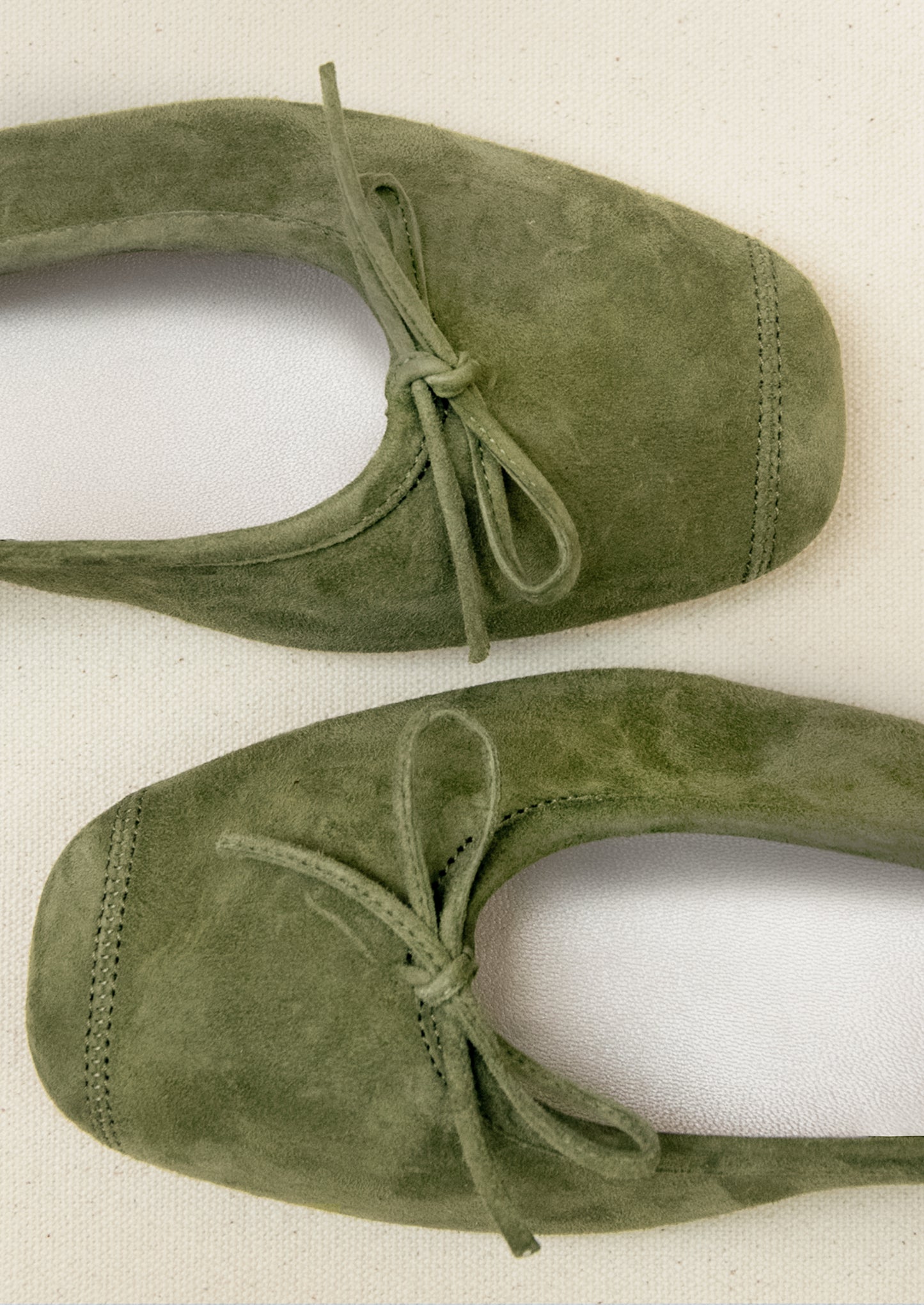 A pair of suede ballet flats in moss green.