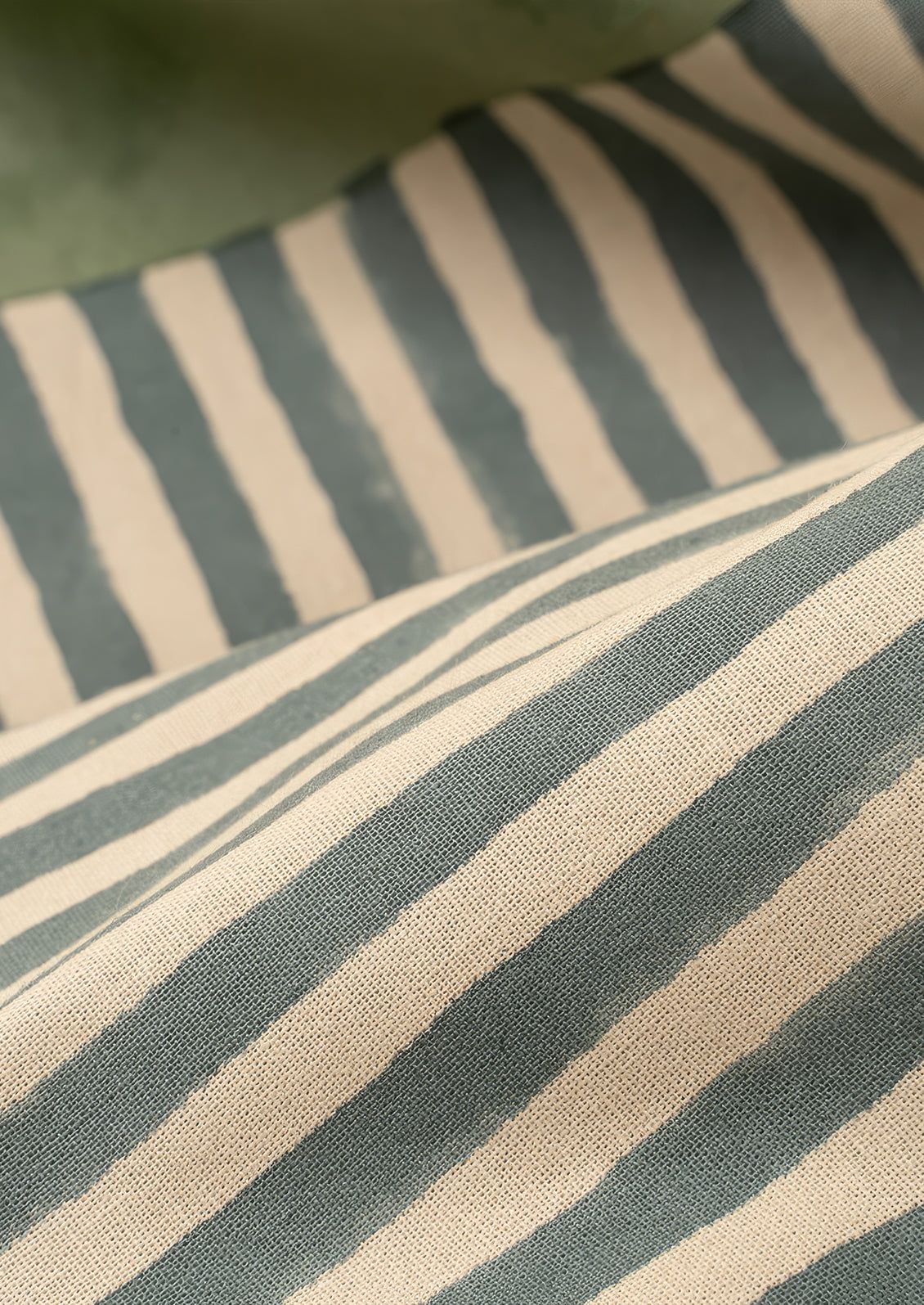 Close-up of fabric with horizontal stripes in green and beige.