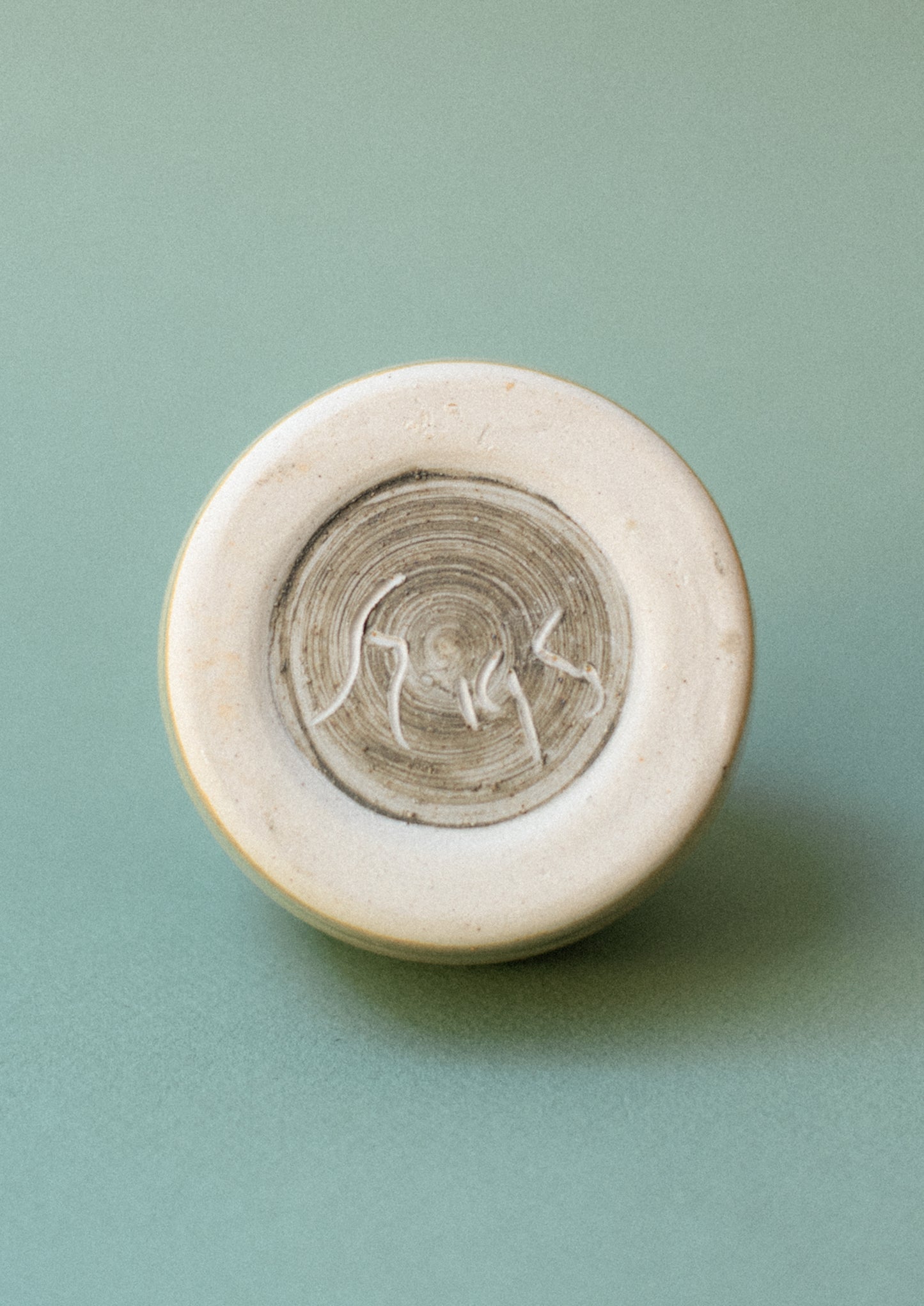 Maker's mark on bottom of ceramic jar.