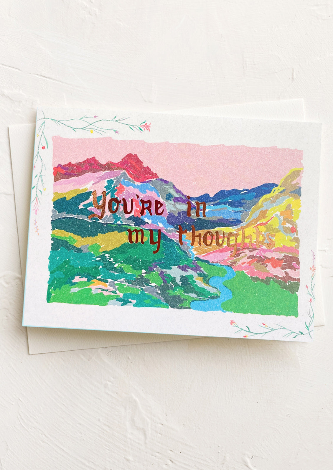 Greeting card with colorful landscape illustration and 'You're in my thoughts' text on a white background