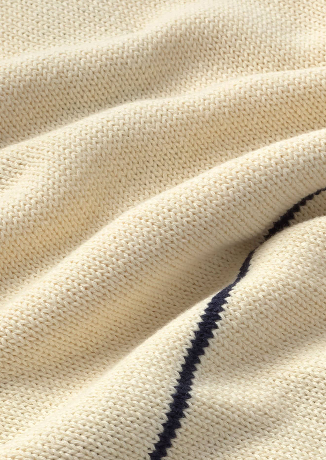 Close-up of beige fabric with a dark blue stripe