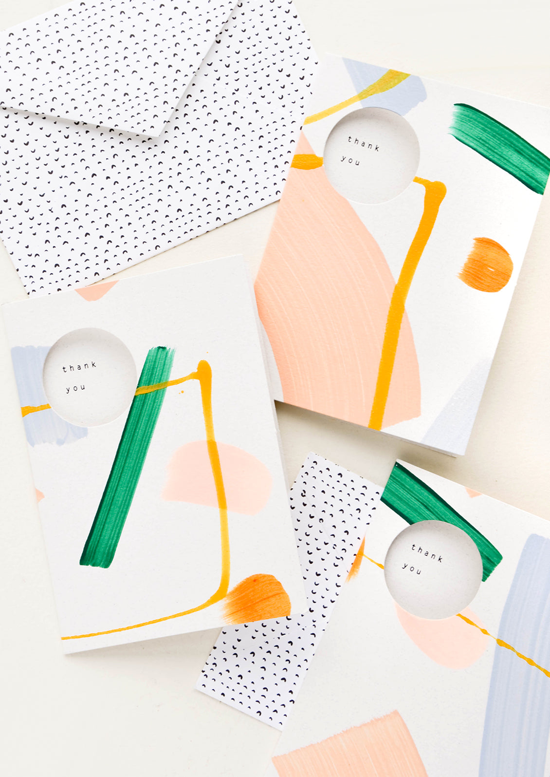 Hand painted thank you cards with abstract paint strokes. Circle cutouts on front with "Thank you" printed inside card.
