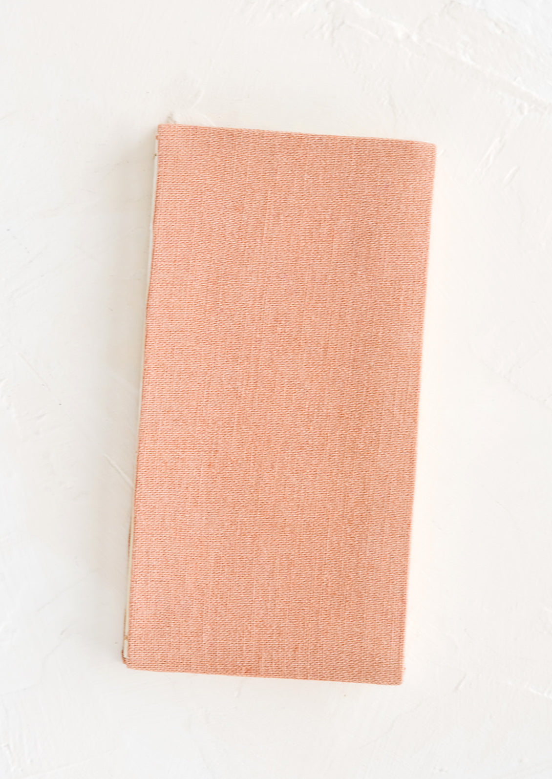 A cloth-covered notebook in naturally dyed rose hue.