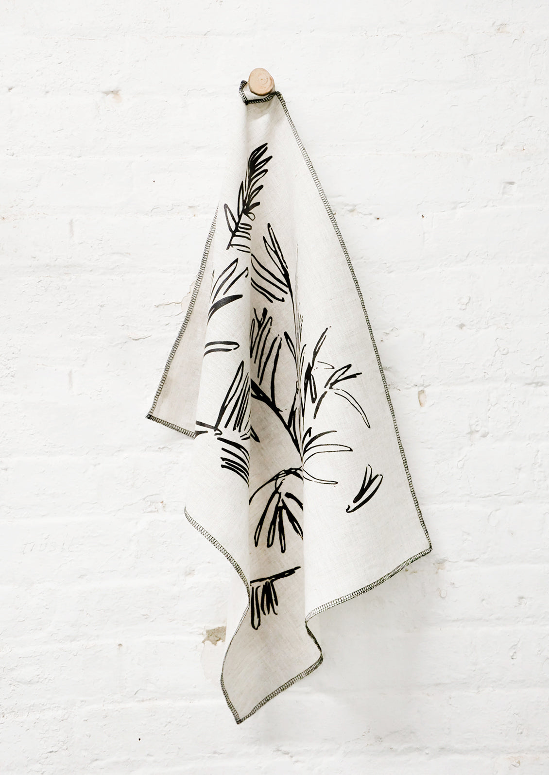 Screen Printed Palm Leaf Linen Tea Towel Hanging On Hook - LEIF
