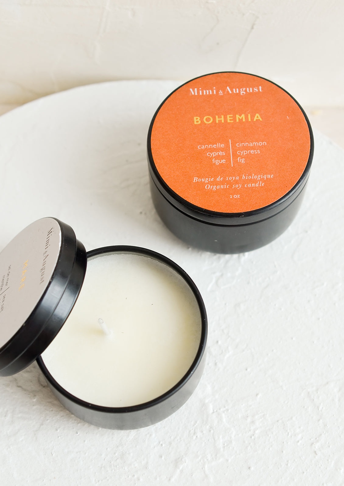 Small soy candles in black metal tins.