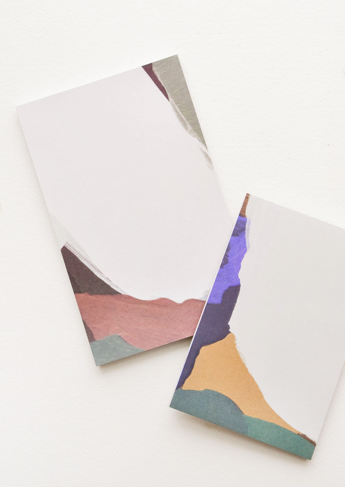 Two notepads, decorated with colorful abstract shapes.