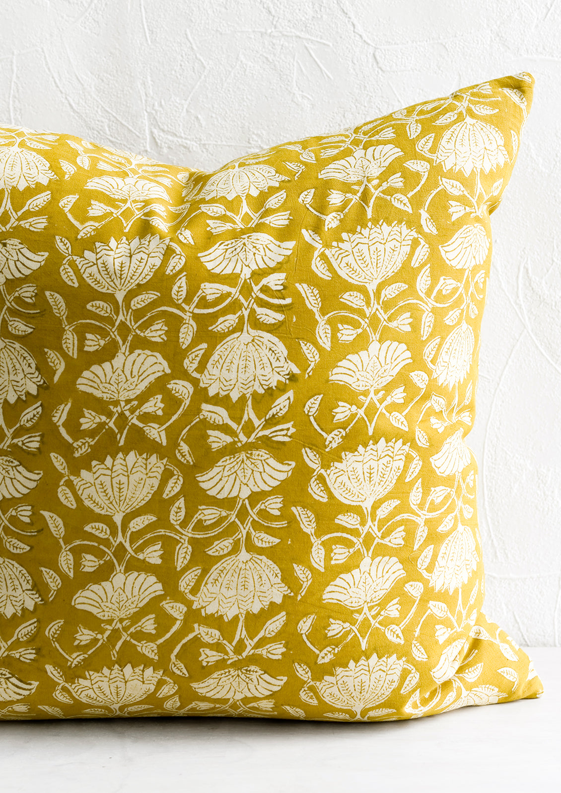 A pillow in yellow block print fabric.