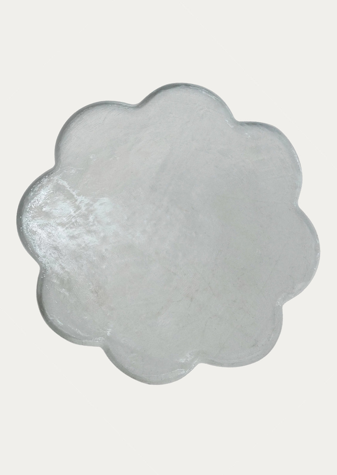 Flower-shaped glass tray with a textured surface.