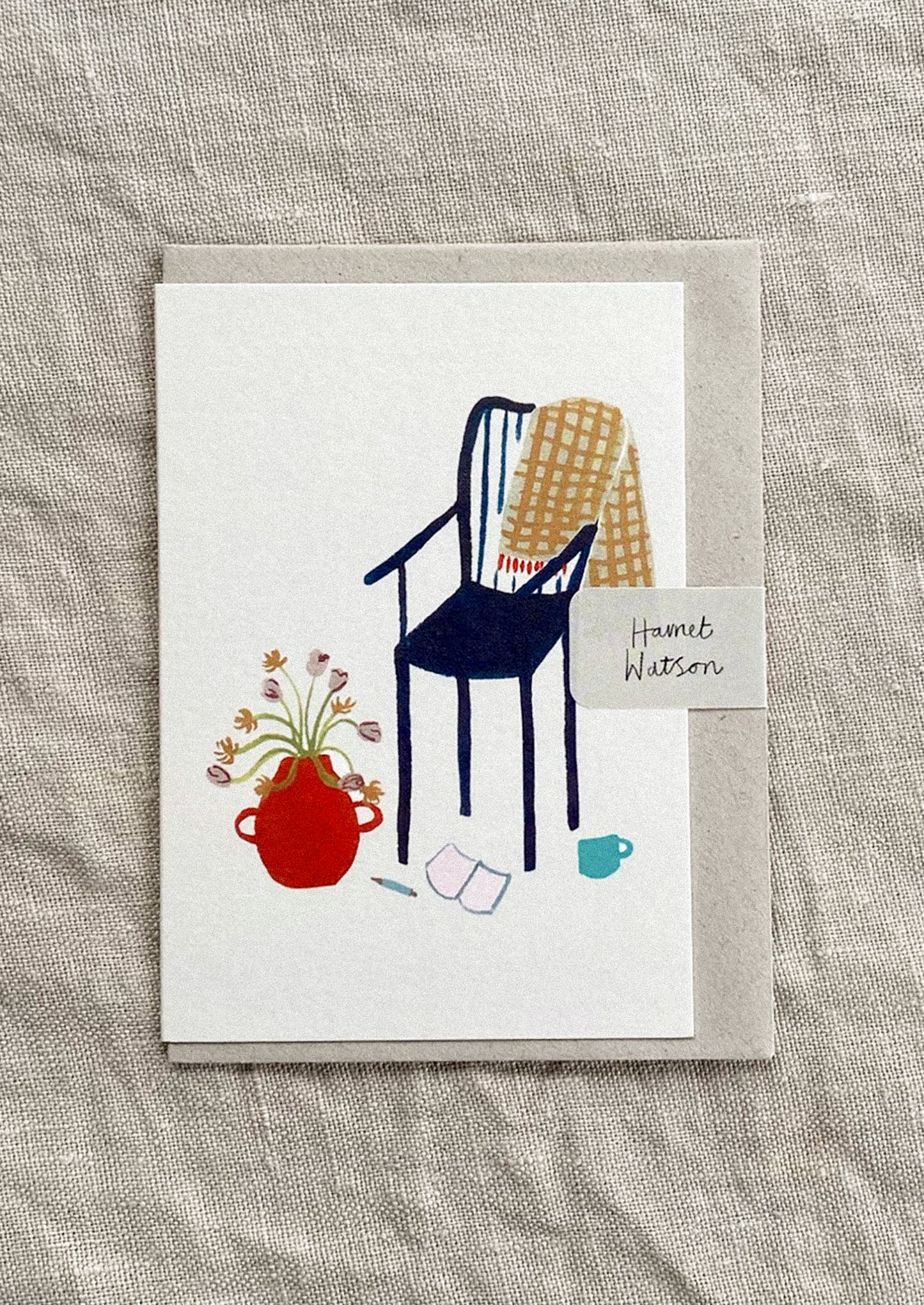 Illustrated card with a chair, vase, and other objects on a textured surface
