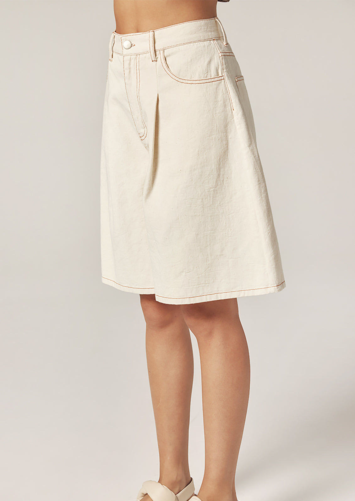 White denim skirt worn by a person on a plain background
