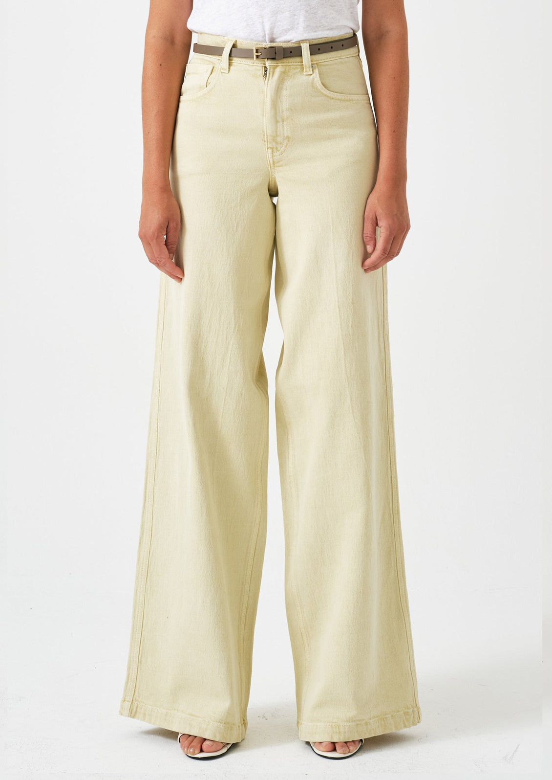 A person wearing a pair of long wide leg jeans in butter yellow color.