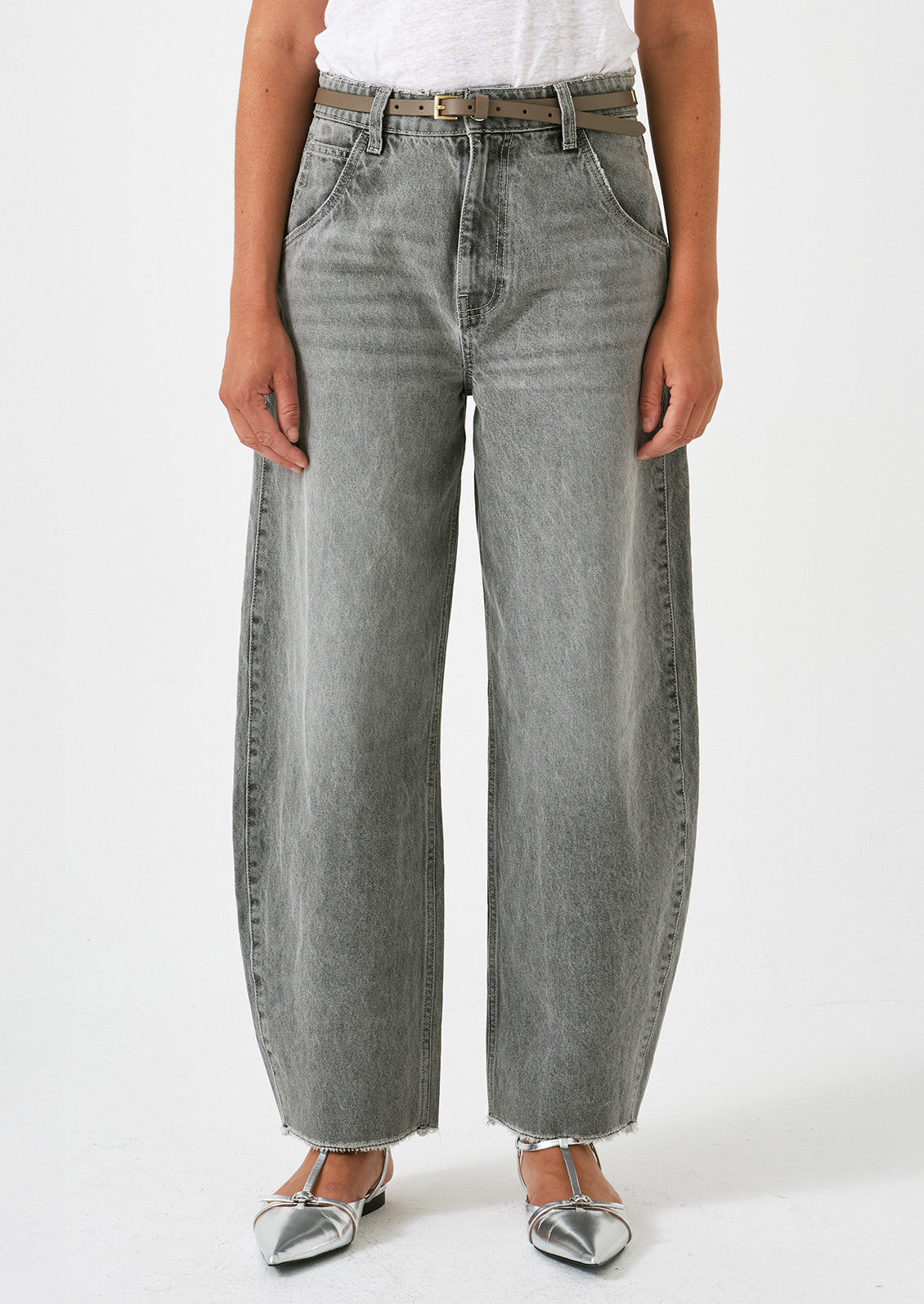 A woman wearing a pair of barrel leg jeans in grey wash.