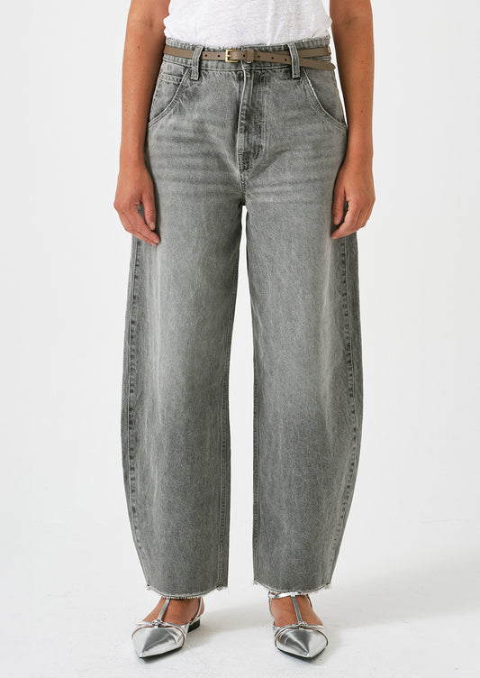 A woman wearing a pair of barrel leg jeans in grey wash.